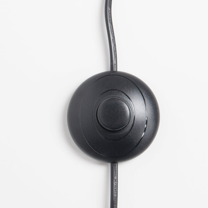 Black circular device with a cable on a white background