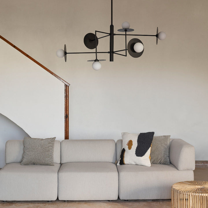 Modern living room with a beige sectional sofa, decorative pillows, and a stylish chandelier.