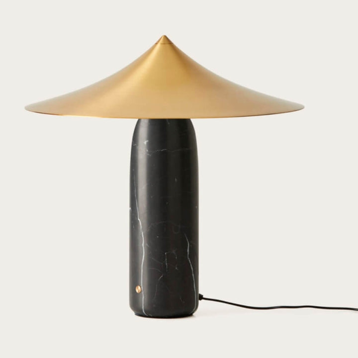 Table lamp with a gold shade and black base on a white background