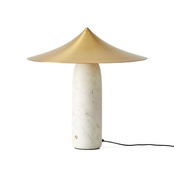 Table lamp with gold shade and marble base on a white background