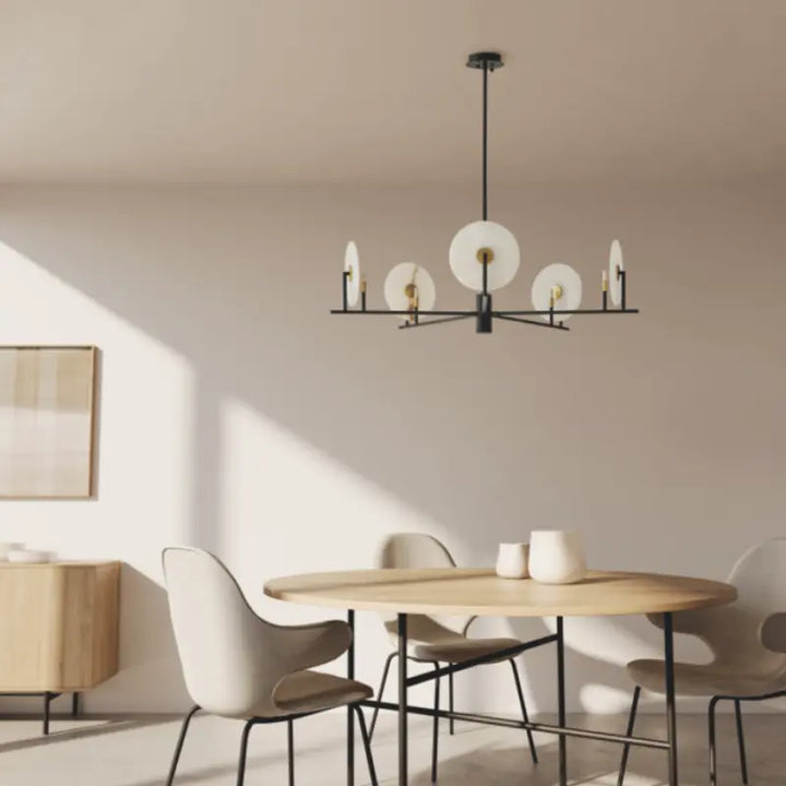 Modern dining room with a chandelier, table, and chairs.