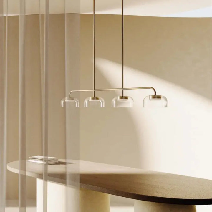 Modern pendant light fixture hanging above a table with a neutral decoration by Bazar Mondiale.