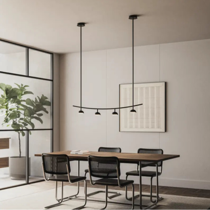 Modern dining room with wooden table, black chairs, and pendant lights. Interior Design by Bazar Mondiale and Aromas Del Campo