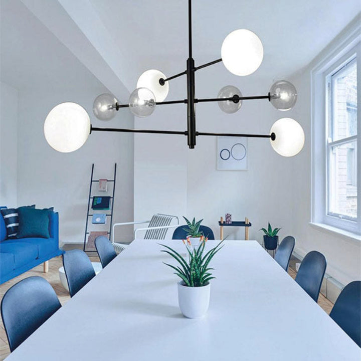 Modern office space with a chandelier, blue chairs, and a white table.
