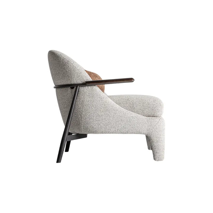 Side view of Herzele Armchair with sloped back and wood arm detail. Only at Bazar Mondiale high end furniture and exclusive pieces.