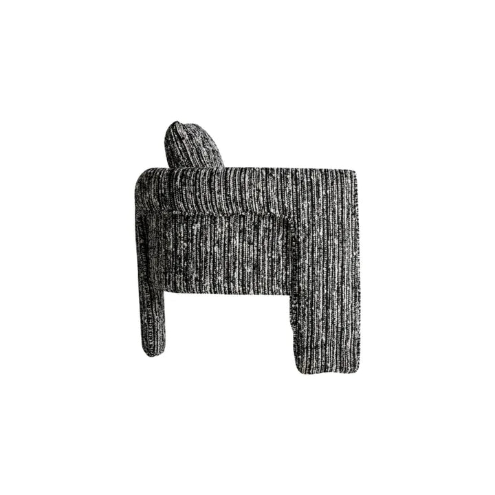 Frontal view of Kostov Armchair with dense cushions and black texture. Only at Bazar Mondiale high end furniture and exclusive pieces.